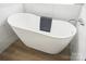 Close-up of a modern soaking tub featuring a towel and wood flooring at 2945 Christian Scott Ln, Charlotte, NC 28214