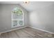 Bright bedroom with an arched window, light gray walls, and wood flooring at 2945 Christian Scott Ln, Charlotte, NC 28214