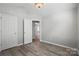 Neutral bedroom featuring light gray walls, wood floors, a decorative light fixture, and white trim at 2945 Christian Scott Ln, Charlotte, NC 28214