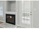 Modern fireplace with a marble surround, and neutral wall color adjacent to a white door and window at 2945 Christian Scott Ln, Charlotte, NC 28214