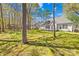 Lush backyard with mature trees, a wooden fence, and well-maintained lawn, offering a serene outdoor space at 3002 Enderbury Dr, Indian Trail, NC 28079