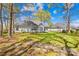 Landscaped backyard with lush grass, mature trees, and brick pavers leading to serene outdoor living at 3002 Enderbury Dr, Indian Trail, NC 28079
