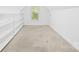 Bright bedroom with neutral walls, carpeted floors, a window with blinds, and built-in shelving for storage at 3002 Enderbury Dr, Indian Trail, NC 28079