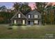 Two-story home with brick and siding, black shutters, and a well-manicured lawn at dusk at 3018 Corinth Church Rd, Monroe, NC 28112