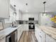 Kitchen boasts white cabinets, granite countertops, stainless steel appliances and modern lighting at 3018 Corinth Church Rd, Monroe, NC 28112