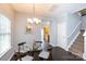 Bright dining area with a glass table, chandelier, and a staircase to the side at 3138 Golden Dale Ln, Charlotte, NC 28262