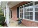 Covered front porch featuring brick facade, white columns, and a chair to enjoy the outdoors at 3138 Golden Dale Ln, Charlotte, NC 28262