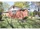 A cozy brick home featuring a well-maintained yard, side garden, and a classic design with mature trees at 3220 Wiseman Dr, Charlotte, NC 28227