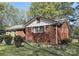 A cozy brick home featuring a well-maintained yard, side garden, and a classic design with mature trees at 3220 Wiseman Dr, Charlotte, NC 28227