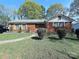 Charming brick home with manicured landscaping, featuring a cozy front yard and driveway in a peaceful neighborhood at 3220 Wiseman Dr, Charlotte, NC 28227