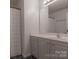 Bathroom featuring a vanity with white cabinets, chrome hardware, and a large mirror at 3712 Autumn Gold Ct, Charlotte, NC 28278