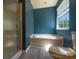Bathroom showing a walk-in shower and soaking tub with blue accent wall at 3712 Autumn Gold Ct, Charlotte, NC 28278