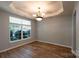 Inviting dining area featuring wood floors, large window, and stylish chandelier at 3712 Autumn Gold Ct, Charlotte, NC 28278
