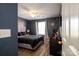 Comfortable bedroom with dark blue walls, wood floors, and a ceiling fan at 4002 Shadow Pines Cir, Indian Trail, NC 28079