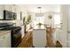 Modern kitchen with updated appliances, white cabinets, an island with granite countertop, and wood flooring at 4002 Shadow Pines Cir, Indian Trail, NC 28079