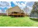 Landscaped backyard with green lawn, trampoline, and wooden deck attached to a home with light-colored siding at 4058 Canvas Ave, Rock Hill, SC 29732