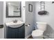 Well-lit half bathroom with modern sink, vanity, and toilet, and featuring classic wainscoting at 4058 Canvas Ave, Rock Hill, SC 29732