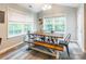 Bright dining room with modern table, bench seating, large windows, and stylish wood-look flooring at 4058 Canvas Ave, Rock Hill, SC 29732