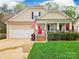 Charming home featuring a bright red front door, a covered porch and an attached two-car garage at 4058 Canvas Ave, Rock Hill, SC 29732