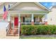 Inviting covered front porch with a cozy porch swing and steps leading up to a bright red front door at 4058 Canvas Ave, Rock Hill, SC 29732