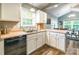 Bright kitchen area enhanced by natural light, featuring white cabinets, stainless steel sink, and an adjacent dining space at 4058 Canvas Ave, Rock Hill, SC 29732