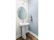 Half bathroom featuring a pedestal sink, decorative oval mirror, and updated flooring at 4112 Steel Way, Sherrills Ford, NC 28673