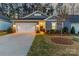 Inviting home exterior with a well-manicured lawn, illuminated entryway, and attached two-car garage at 4427 Bright Rd, Charlotte, NC 28214