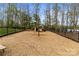 Community playground features a slide and play equipment, fully fenced with a wood chip ground cover and mature tree surround at 4427 Bright Rd, Charlotte, NC 28214