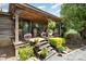 Inviting front porch decorated with plants, flowers, and rocking chairs, showcasing rustic charm at 4478 Fork Rd, Norwood, NC 28128