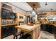 Charming kitchen with black cabinets, butcher block countertops, a wood island and stainless steel appliances at 4478 Fork Rd, Norwood, NC 28128