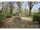 Backyard patio featuring stone pavers, firepit, and wooded landscaping at 469 Augusta Dr, Statesville, NC 28625