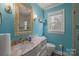 Stylish bathroom with marble countertop, decorative mirror, and vibrant blue walls at 469 Augusta Dr, Statesville, NC 28625