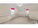 Empty bedroom featuring carpeting, two windows and crisp white trim at 469 Augusta Dr, Statesville, NC 28625