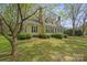 Side view of yellow two-story home with blue shutters and mature landscaping at 469 Augusta Dr, Statesville, NC 28625