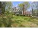 Wide view of two-story yellow home with blue shutters, brick chimney and landscaped front yard at 469 Augusta Dr, Statesville, NC 28625