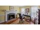 A home office with a brick fireplace, hardwood floors, and natural light from lace-curtained windows at 469 Augusta Dr, Statesville, NC 28625