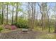 Backyard area featuring an outdoor fireplace and wooded backdrop at 485 Camrose Ne Cir, Concord, NC 28025