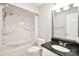 Bathroom featuring a shower-tub combination, white fixtures, and sleek black countertop at 485 Camrose Ne Cir, Concord, NC 28025