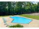 A refreshing community pool surrounded by lounge chairs and mature trees at 485 Camrose Ne Cir, Concord, NC 28025