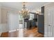 Bright dining area with chandelier, dark cabinets, wood floors, and sliding door to deck at 485 Camrose Ne Cir, Concord, NC 28025