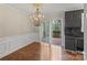 Bright dining room with hardwood floors, elegant chandelier, wainscoting, dark cabinets, and sliding door to deck at 485 Camrose Ne Cir, Concord, NC 28025