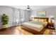 Relax in this inviting main bedroom with a ceiling fan, wood floors, and sunny windows at 485 Camrose Ne Cir, Concord, NC 28025
