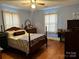 Bedroom features hardwood floors, ceiling fan, and traditional wooden furniture with lots of light at 523 29Th Avenue Nw Dr, Hickory, NC 28601