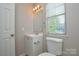 A bathroom featuring a well-lit vanity with a mirror and a toilet near a window at 6020 Running Deer Rd, Charlotte, NC 28214