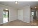 Bedroom with neutral walls, double closet, and view of backyard and hallway at 6020 Running Deer Rd, Charlotte, NC 28214