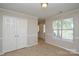 Bedroom with neutral walls, double closet, window, and trim work at 6020 Running Deer Rd, Charlotte, NC 28214
