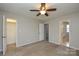 Bedroom featuring neutral walls, carpet flooring, ceiling fan and three doors, offering plenty of access at 6020 Running Deer Rd, Charlotte, NC 28214