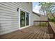 Wooden deck with sliding glass door and exterior wall fixture at 6020 Running Deer Rd, Charlotte, NC 28214