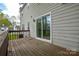 View from the wooden deck highlighting the home's sliding glass doors at 6020 Running Deer Rd, Charlotte, NC 28214