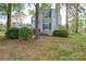 Side view of a charming two-story home with stone accents, black shutters and a nice front lawn at 6020 Running Deer Rd, Charlotte, NC 28214